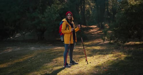 Backpacker Hiker Girl with Hiking Poles Walking Between Trees in a Mountain Forest Hispanic Teenager