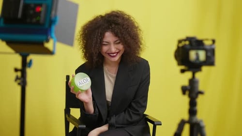 Smiling Woman Holding Skincare Product in Studio