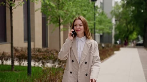 Woman Talks on Mobile Phone Walking in City