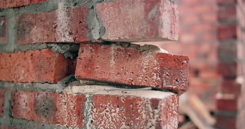 Construction, wall and loose brick at incomplete site, building development and safety hazard