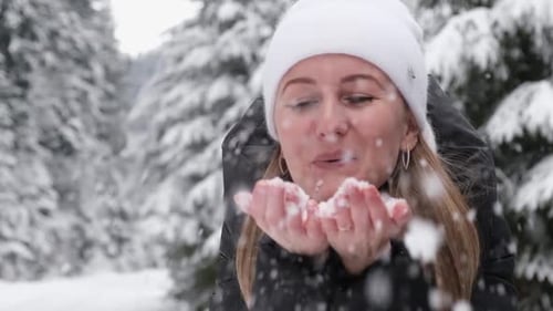 Winter Forest a Girl Blowing Snow with Her Palms