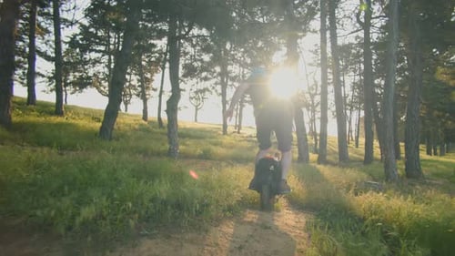 Man Riding Electric Unicycle Through Forest Trail at Sunset