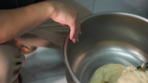 Chef making dough with mixing equipment in bakery, industrial mixing machine. Side view. Close up.