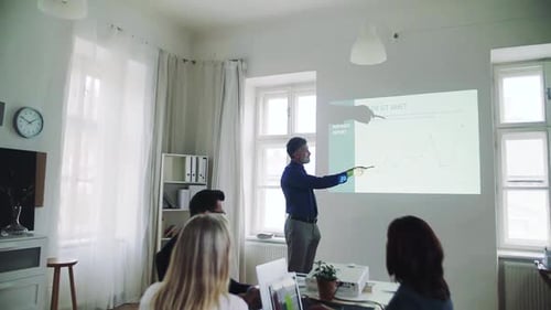 Businessman gives presentation to colleagues in modern office space