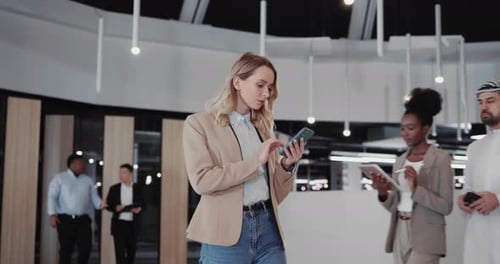 Businesswoman Using Phone in Modern Office Lobby