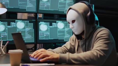 Un ladrón cibernético enmascarado piratea una red informática por la noche