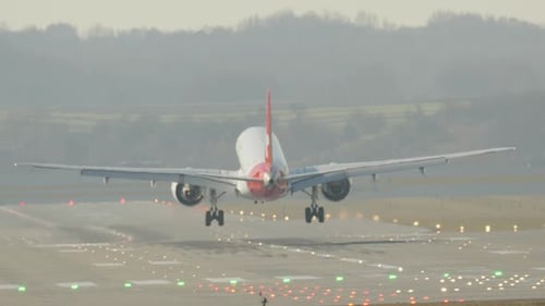 Passenger airplane landing on airport runway during sunset approach