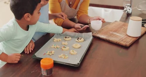 Boys and Woman Decorating Cookies in Kitchen