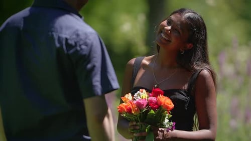 Woman Receives Roses from Man in Garden