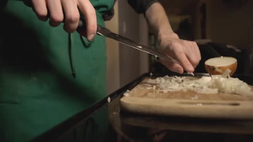 Person Dicing White Onion with Knife on Cutting Board