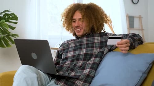 Young Man Online Shopping with Laptop at Home