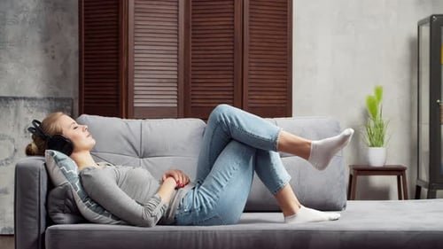 Woman Resting on Couch with Headphones