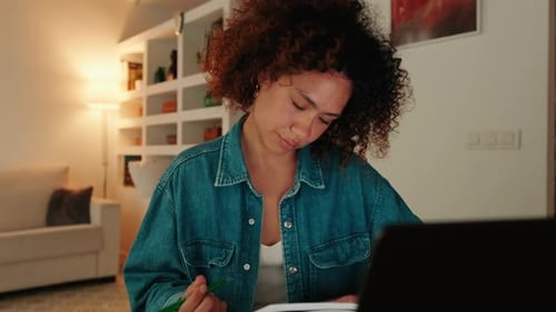 Woman Studying with Laptop and Notebook at Home