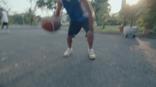 Young Basketball Player Dribbling Ball on Camera at Outdoor Court