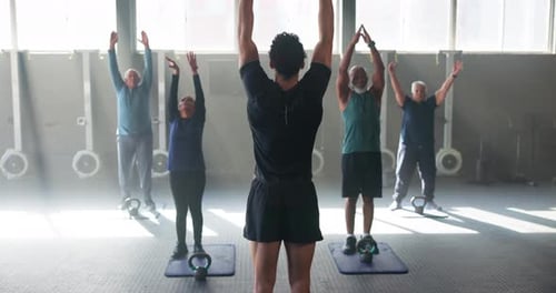 Seniors Exercising in Fitness Studio with Trainer