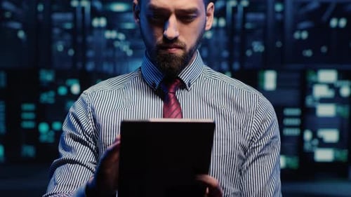 IT Web Technician Working in Data Center with Tablet