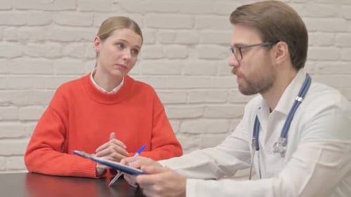 Doctor Listening Female Patient in Clinic