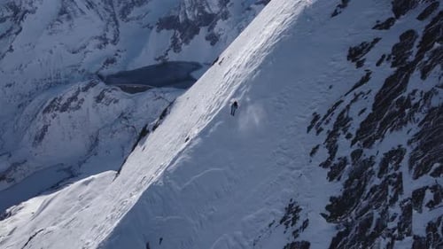 Skier Glides Down Snowy Mountain Slope on Sunny Day