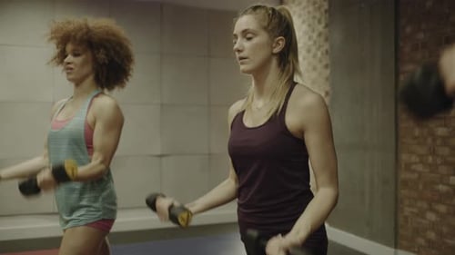 Group of adult women exercising with weights in gym