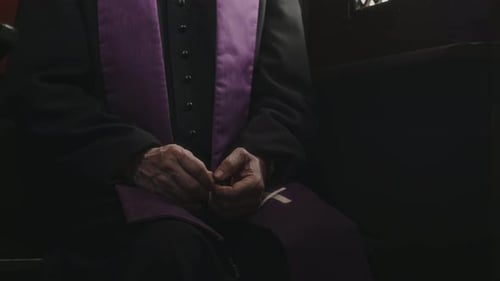 Midsection of Catholic Priest Sitting in Confession Booth
