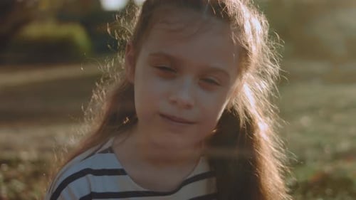Portrait of Pretty Little Girl in a Striped Dress in Park Summer Vacation Happy Childhood Concept