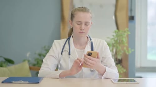 Female Doctor Using Smartphone in Clinic