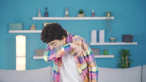 Sick adolescent male sneezing.