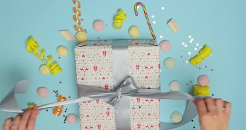 Unwrapping Holiday Gift on Light Blue Background