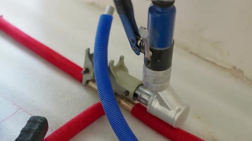 Pressing Brass Manifold Fitting Onto Plastic Pipe During Plumbing Installation