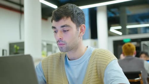 Young Handsome Man Typing on Laptop in the Office