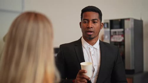 Closeup Rear View of Two Diverse Office Colleagues Drinking Coffee From Paper Cups and Having