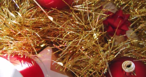 Red and golden Christmas decoration. Ornaments close up tinsel, garland gift and baubles. December c