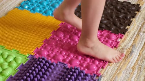 Child Walking on Colorful Orthopedic Massage Mat