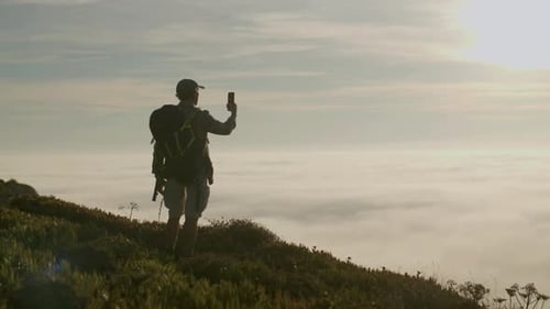 Hiker Standing on Mountain and Taking Photo of Beautiful View