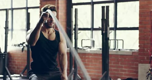 Man, battle rope and fitness in gym with muscle training, health and workout for bodybuilding