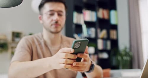 Man Works on Laptop and Uses Mobile Phone