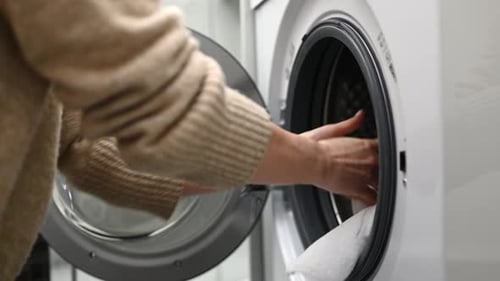 Close Up of Putting Towels in Washing Machine