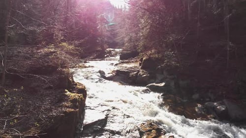 Luftaufnahme eines Gebirgsflusses mit wunderschönem Wasserfall im Nachmittagssonnenlicht