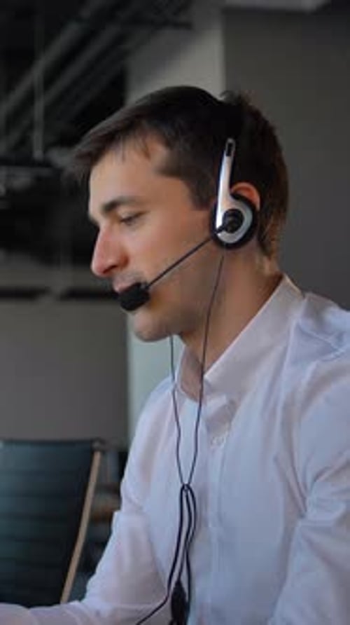 Vertical of Attractive Worker in Office Call Center Talking with Client and Then Smile to Camera