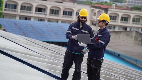 Engineer team checking solar cell with laptop on the roof