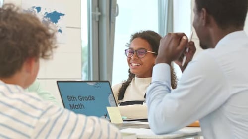 Teacher Explains Math to Students in Classroom