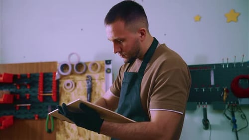 Carpenter Inspecting Wooden Plank in Workshop