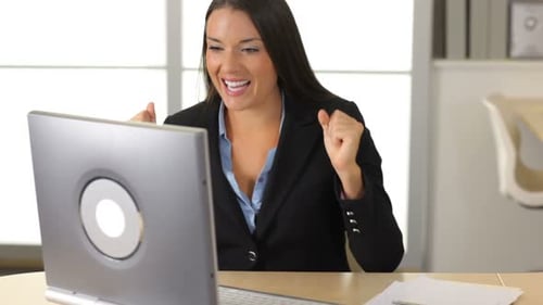 Happy Business Woman Celebrates in Office 20s