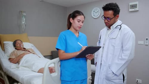 Doctor and Nurse Check on Patient in Hospital
