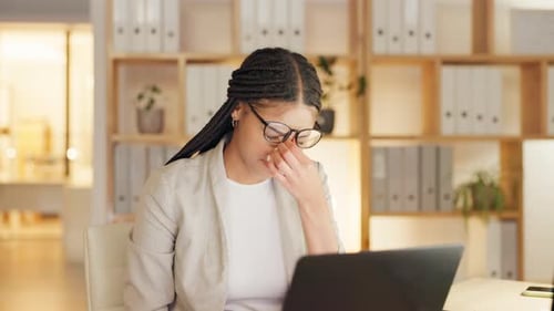 Young Adult Woman at Desk Touching Her Face