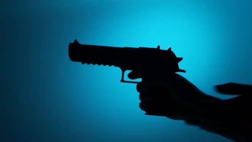 Hand Holds Gun in Dark Silhouette on Blue
