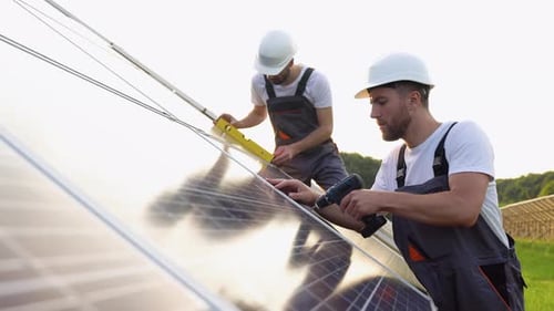 Zwei Solarpanel-Techniker installieren Sonnenkollektoren an einem sonnigen Tag
