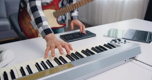 Male Hands Playing Midi Piano Keyboard in Home Studio. Man Makes Electronic Music at Home. Musician