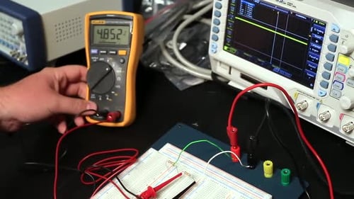Estudiante de electricista comprobando el voltaje y los amperios con multímetro