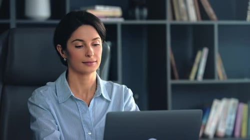 Professional woman working on laptop in modern office setting